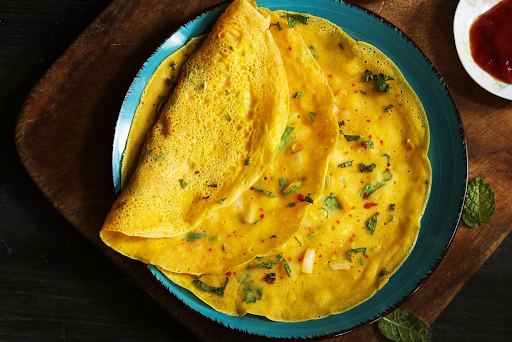 Spicy egg omelette on a teal dinner plate.