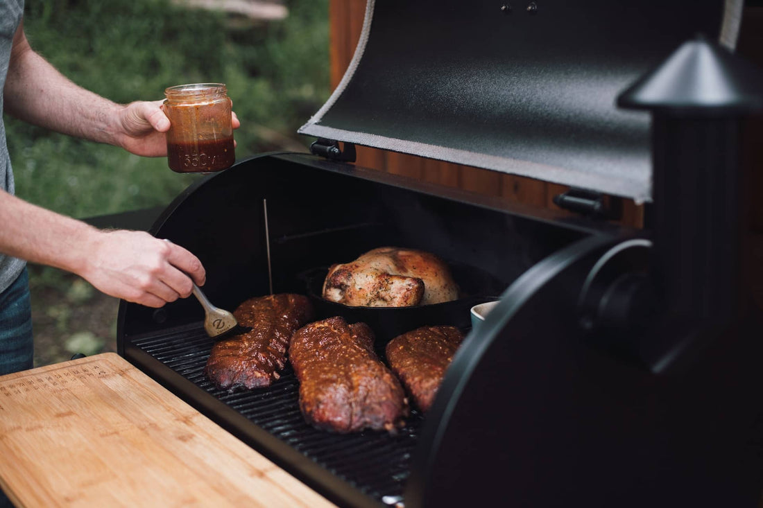 A home cook brushing grilled meats with pepper jelly BBQ sauce