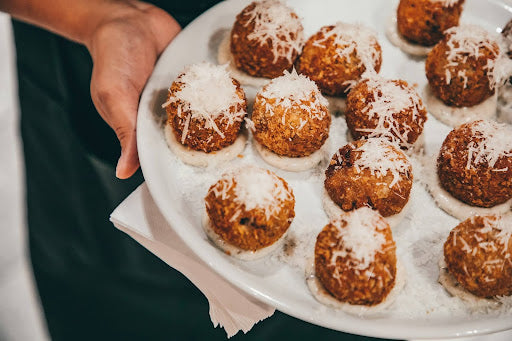 A plate of arancini rice balls topped with shredded cheese