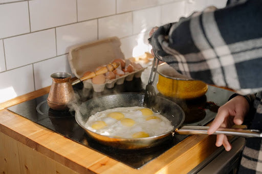 A pan full of eggs frying on a stovetop