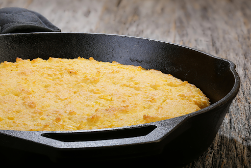A cast iron skillet with fresh corn bread