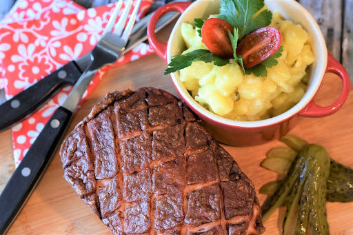 A freshly cooked pepper jelly meatloaf with a side of potatoes
