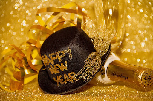 Close-up of a New Year’s Eve party hat next to a bottle of champagne
