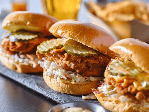 A row of three spicy chicken sandwiches served side by side