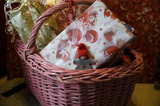 A Christmas-themed gift basket stuffed full of wrapped presents